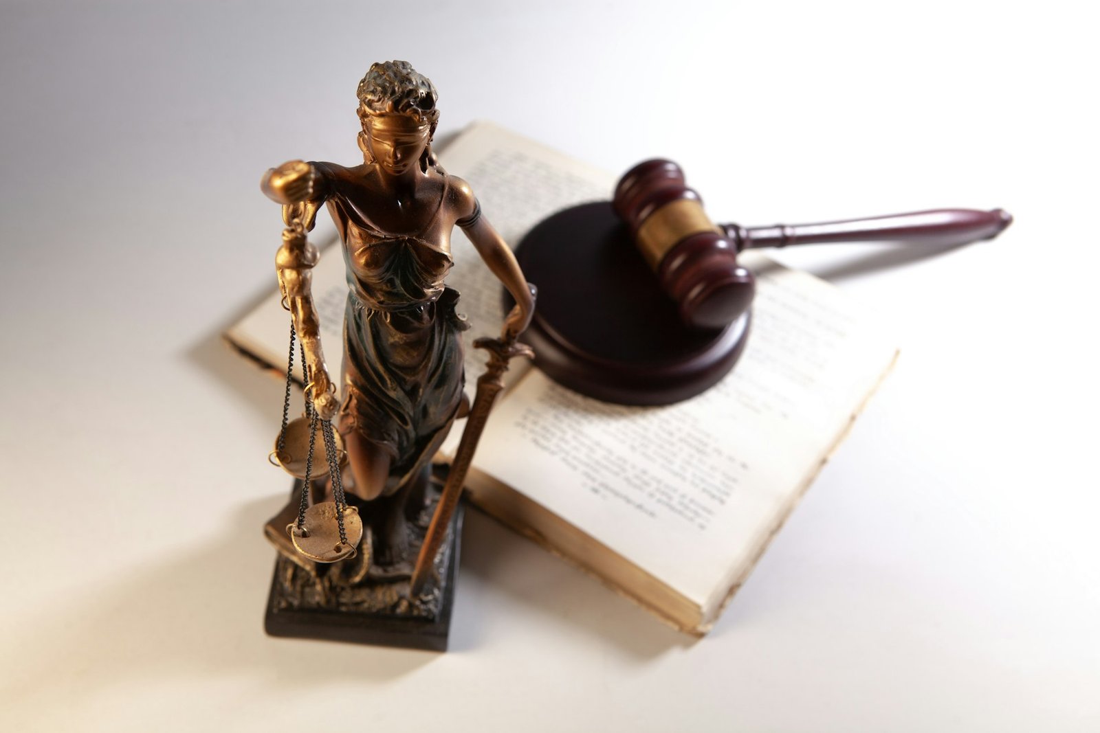 Estatua de la Justicia, mazo y libro abierto sobre una mesa