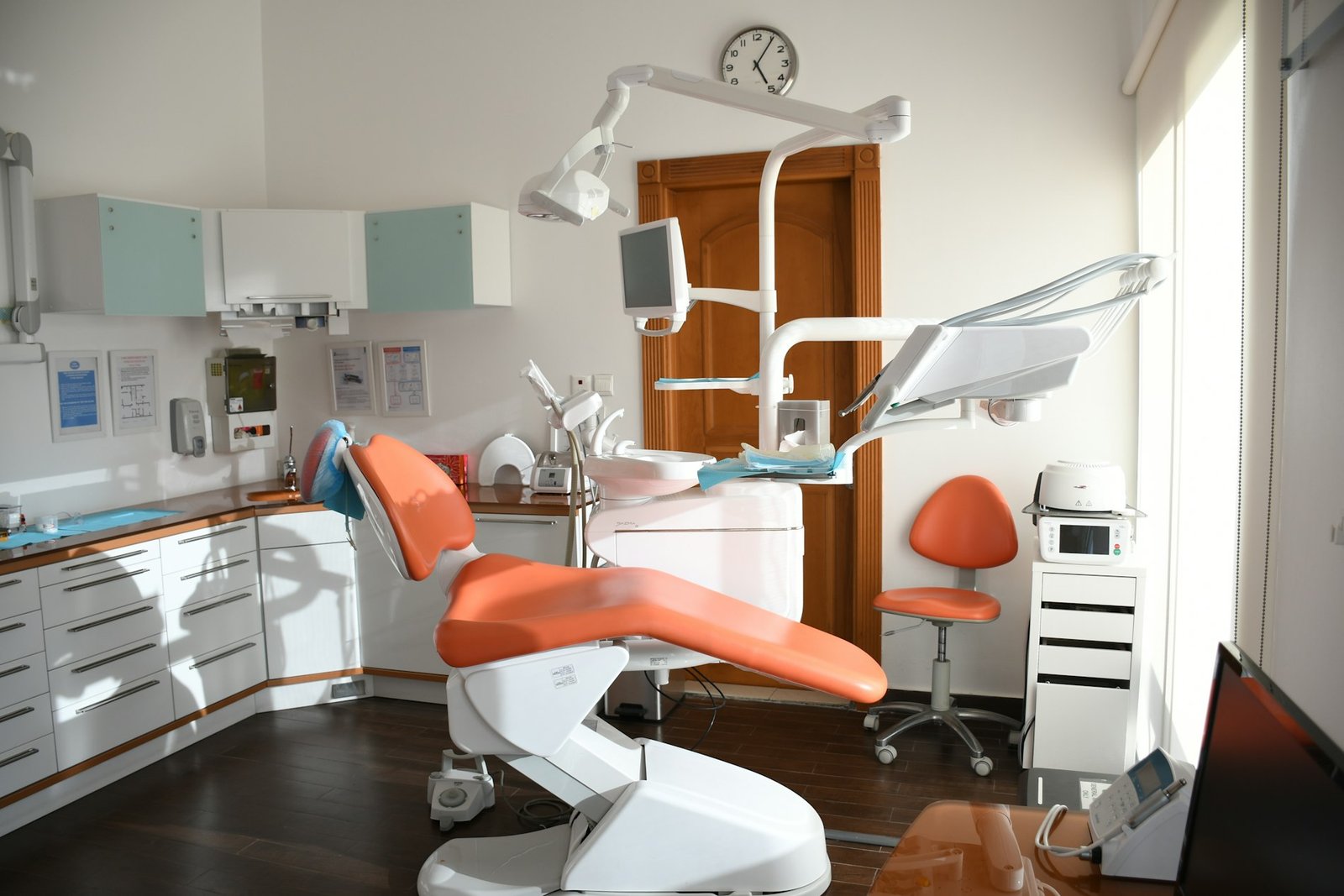Sillón dental naranja en una consulta luminosa