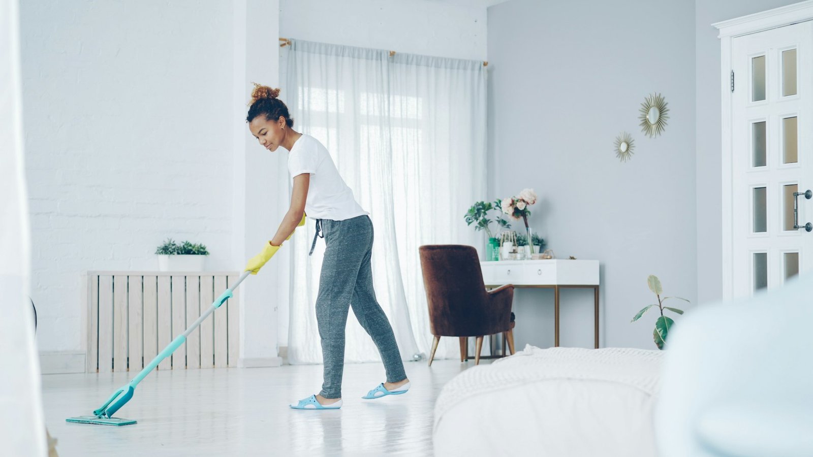 Mujer fregando el suelo de un salón luminoso