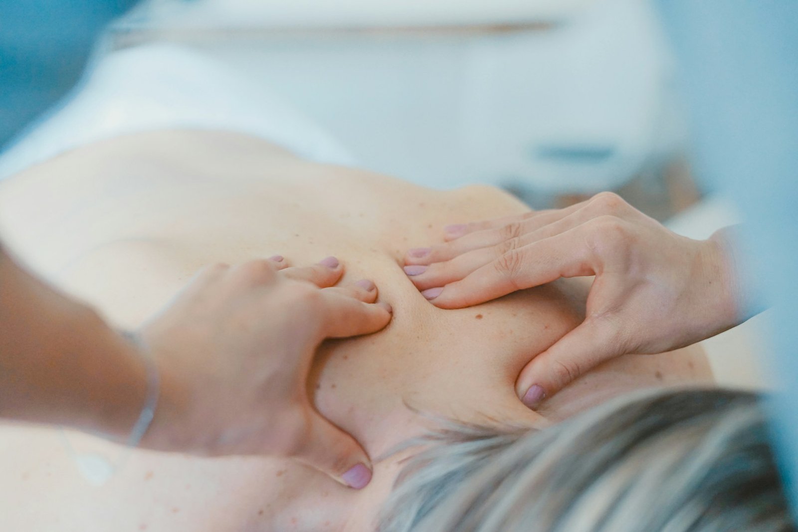 Manos de un fisioterapeuta tratando la espalda de una paciente