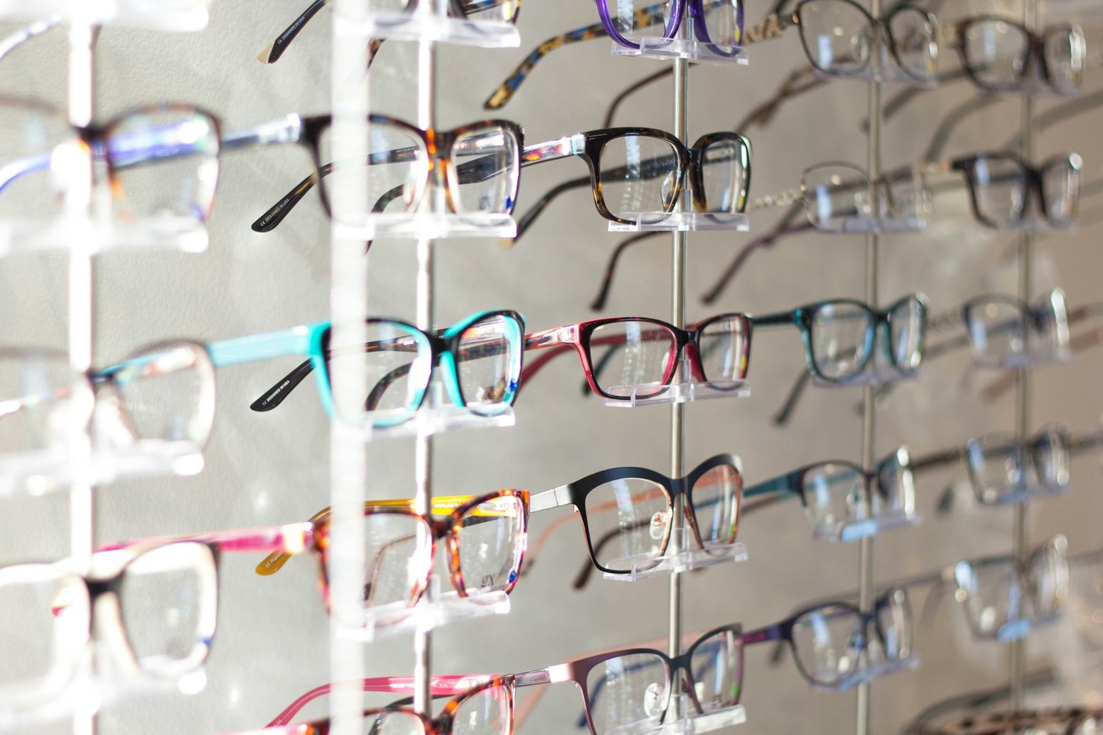 Monturas de gafas de colores expuestas en una óptica