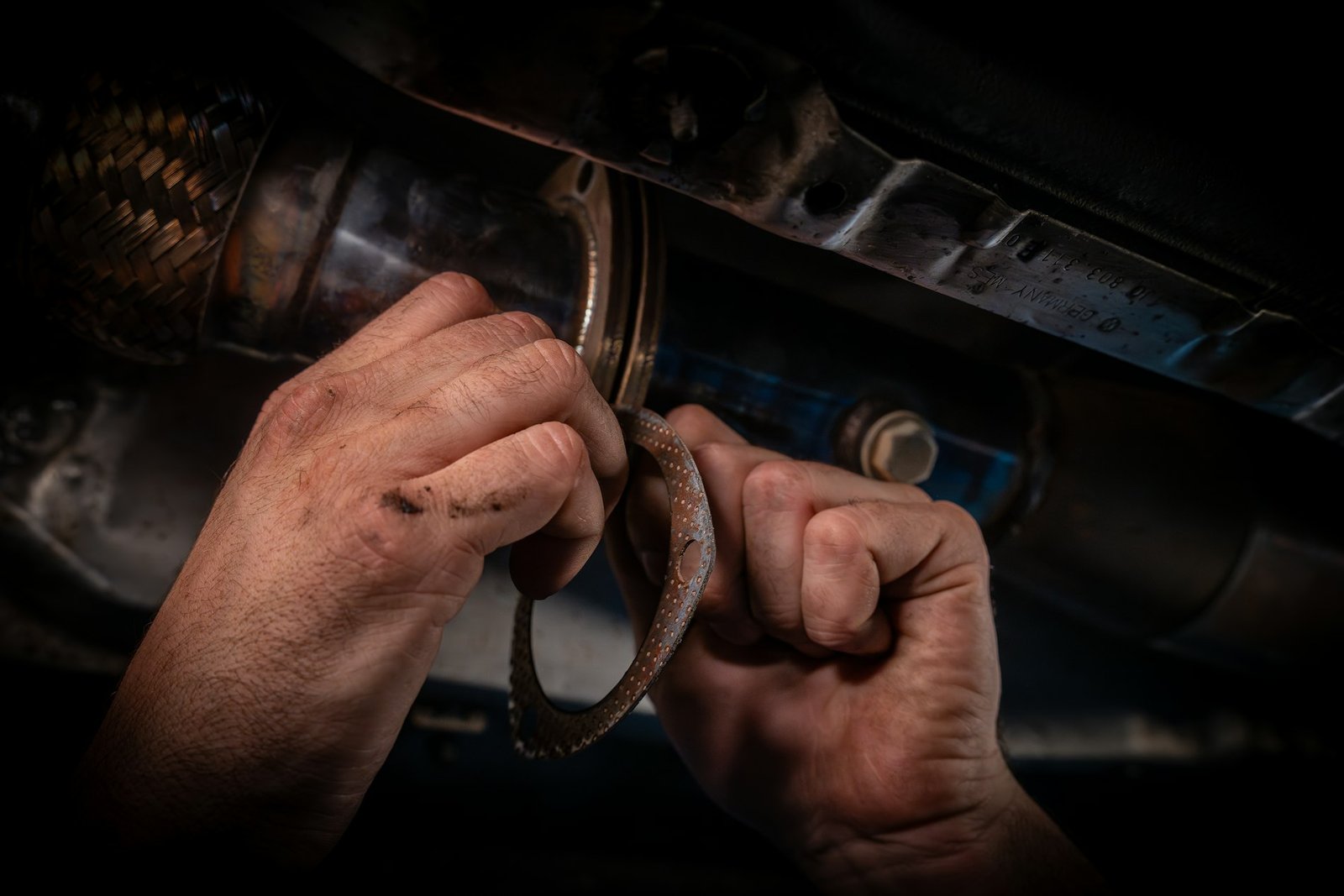 Manos de un mecánico manipulando una pieza del motor