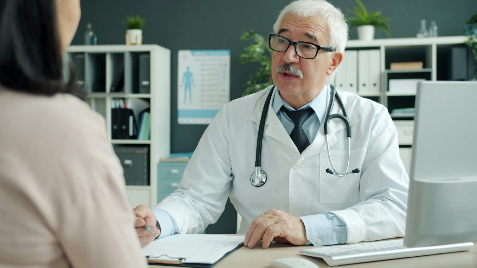 Médico atendiendo a una paciente en su despacho