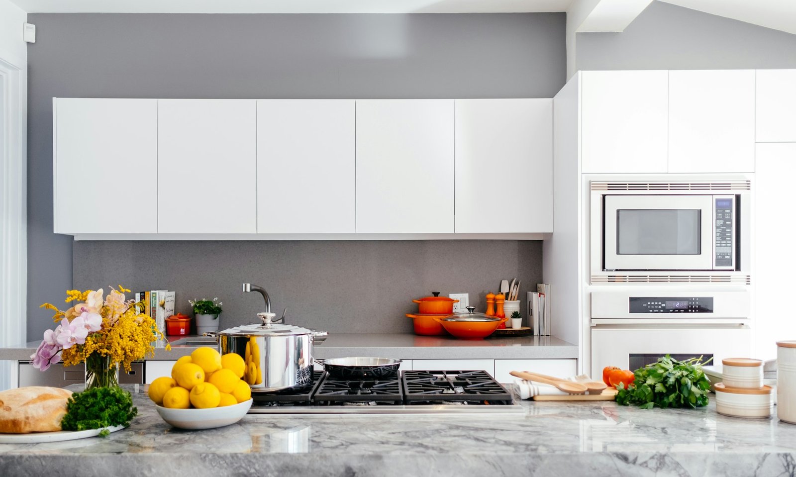 Cocina reformada con muebles blancos y encimera de piedra