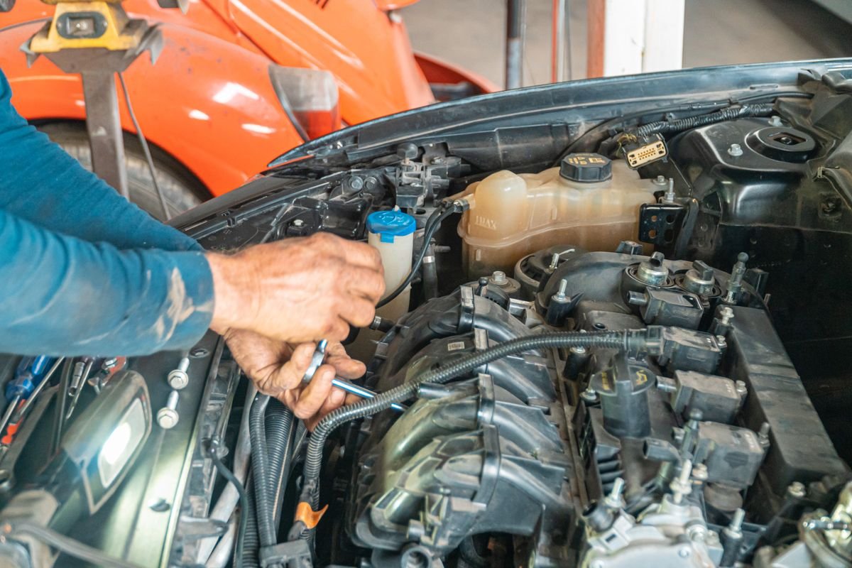 Mecánico revisando el motor de un coche en el taller