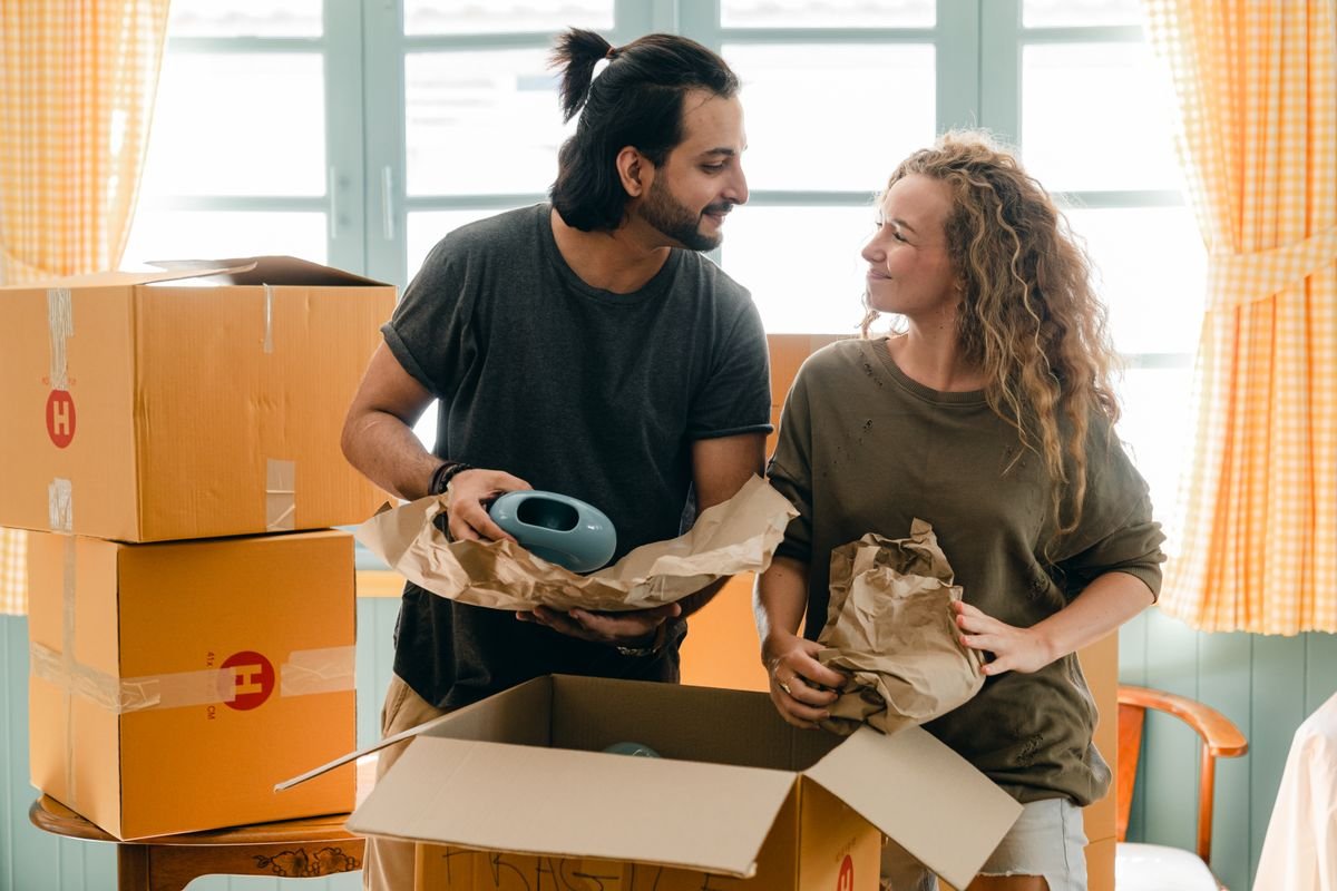 Pareja desembalando cajas de mudanza en su nueva vivienda