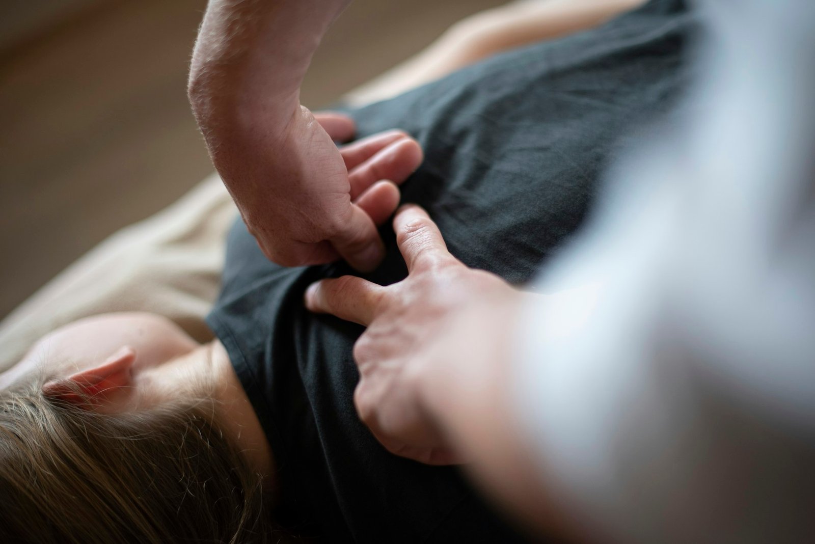 Manos de un fisioterapeuta trabajando sobre la espalda de un paciente