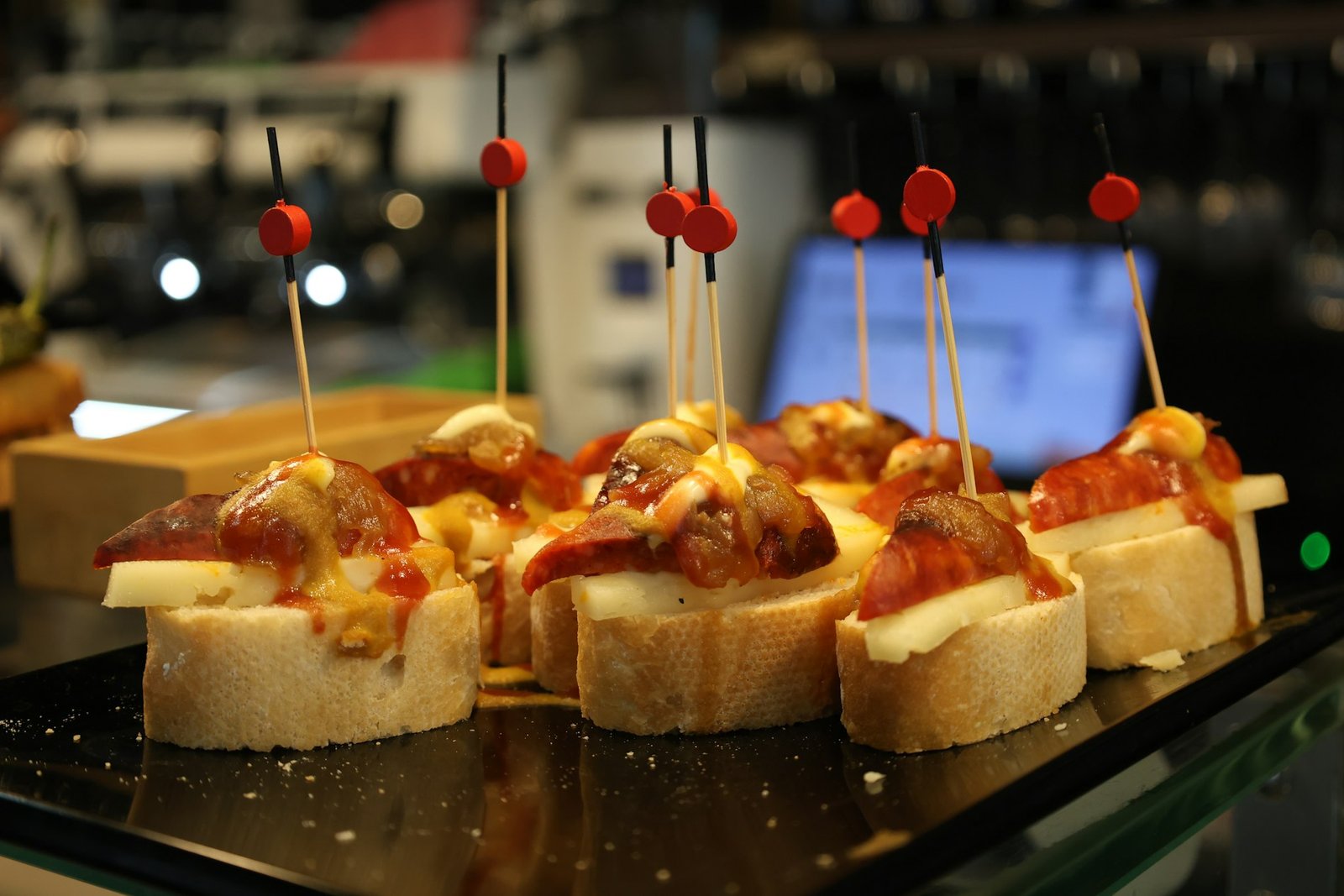 Pintxos de pan con pimiento y queso en una barra