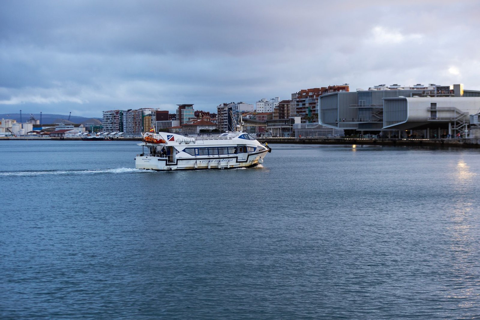 Embarcación cruzando la bahía de Santander al anochecer